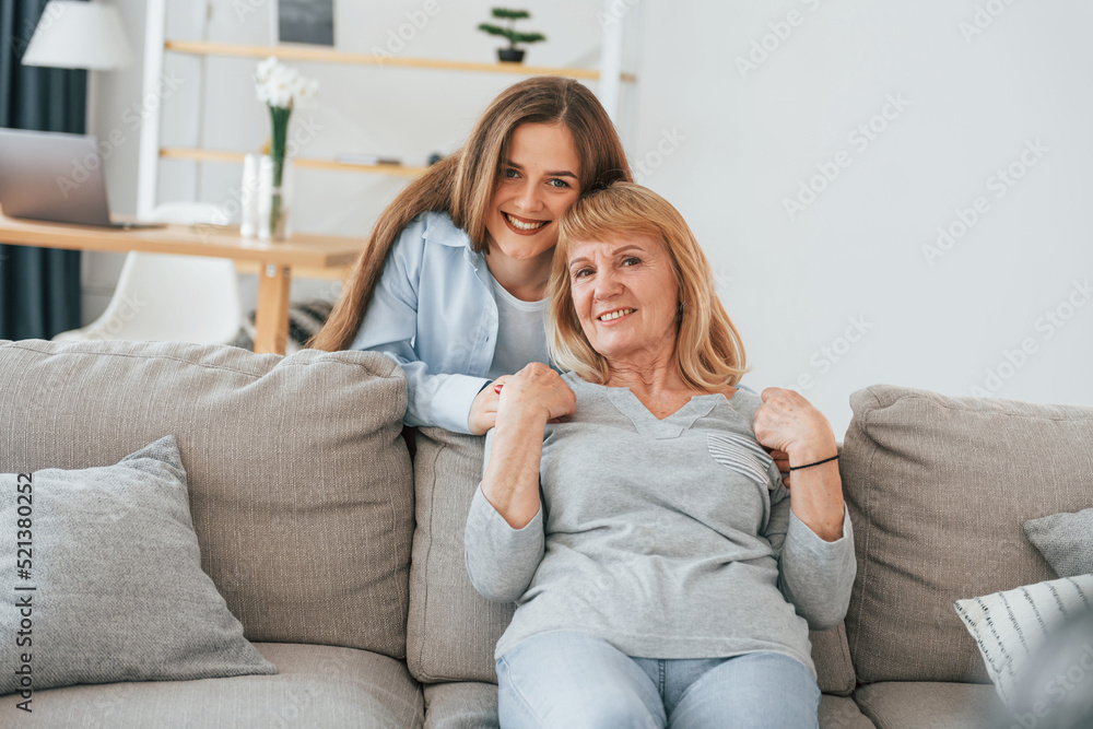 Obraz premium Smiling and looking at the camera. Mother and daughter is together at home