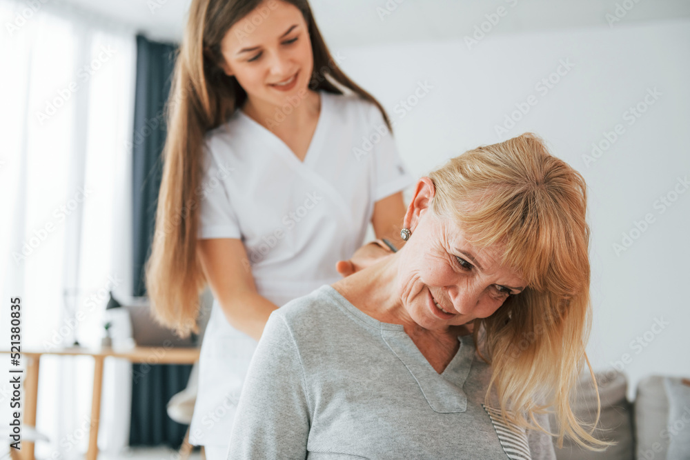 Massaging upper body parts. Senior woman is visiting physician in the office Massaging upper body parts. Senior woman is visiting physician in the office