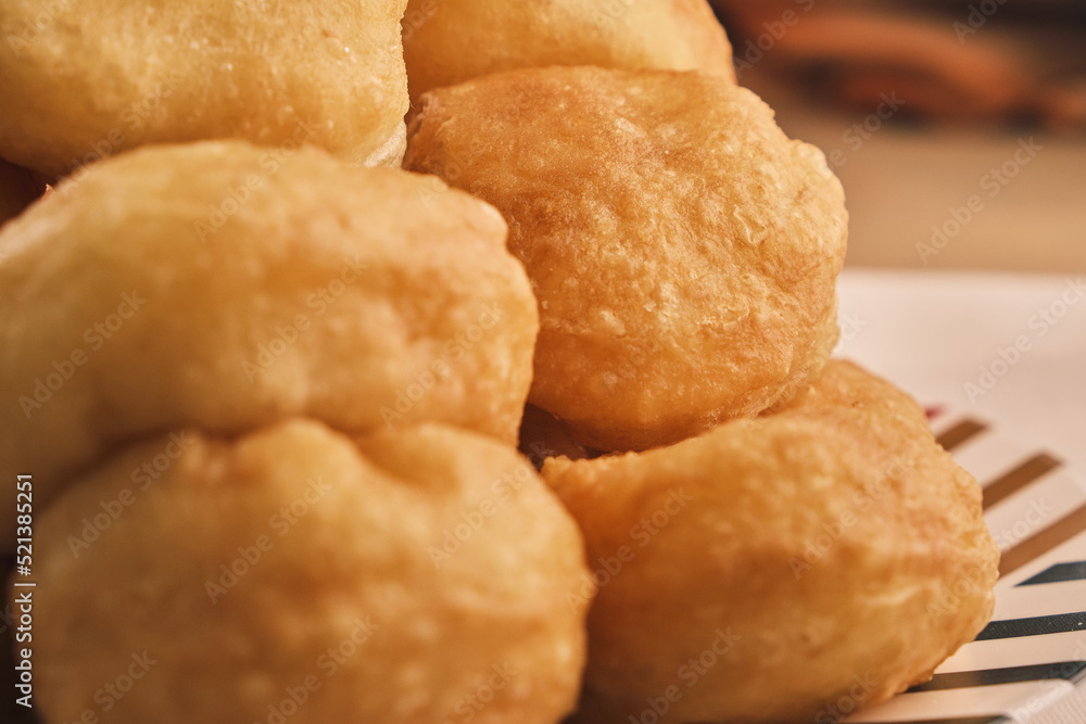 Close up of a lot of freshly baked Boortsog (baursak) traditional food of kazakh in the sunrise at home Close up of a lot of freshly baked Boortsog (baursak) traditional food of kazakh in the sunrise at home