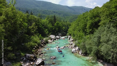 Soca Valley, Slovenia - 4K flying above the emerald alpine river Soca with kayaks and rafting boats going down the river on a bright summer day