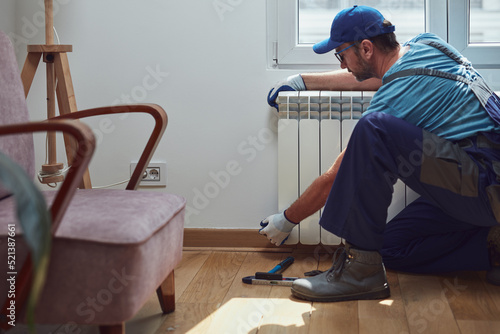 Central heating mechanic and handyman fixing home radiator, gas crisis and seasonal issues.