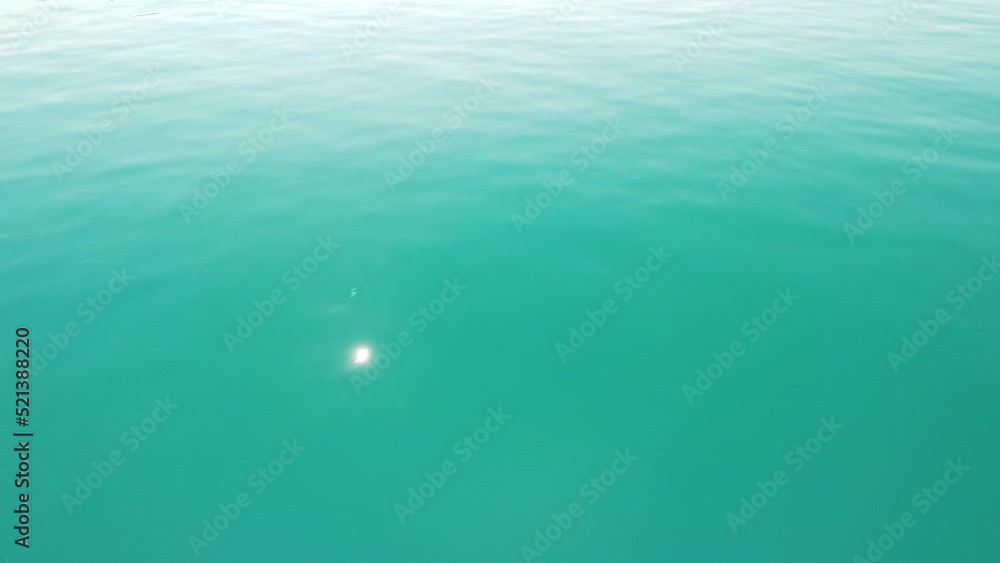 Abstract aerial sea summer ocean sunset nature background. Small waves on water surface in motion blur with golden bokeh lights from sun. Holiday, vacation and recreational concept. Slow motion Abstract aerial sea summer ocean sunset nature background. Small waves on water surface in motion blur with golden bokeh lights from sun. Holiday, vacation and recreational concept. Slow motion