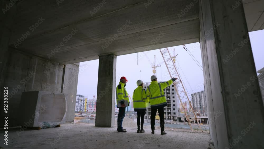 three civil engineers of development company are watching construction site, rear view three civil engineers of development company are watching construction site, rear view