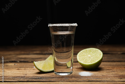 Mexican Tequila shot with salt and lime on wooden table