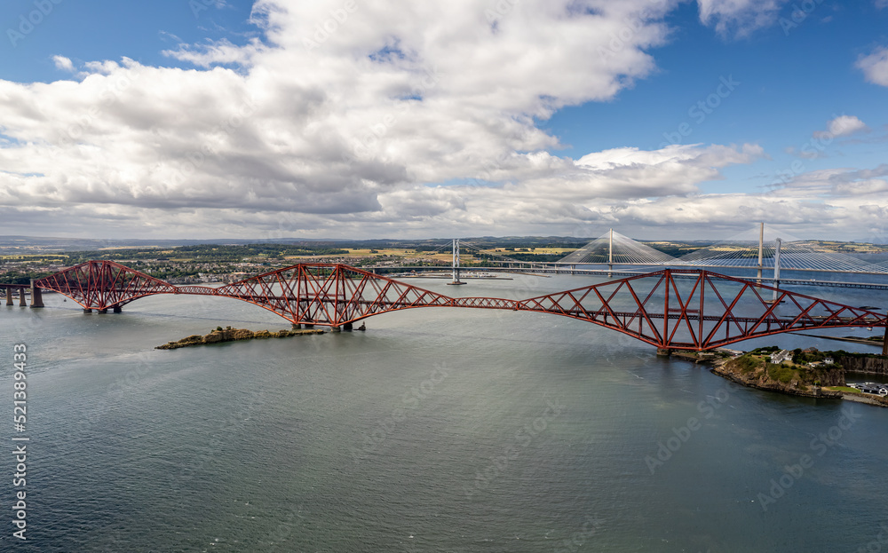 Obraz premium The drone aerial view of the Forth Bridges and the new Queensferry Crossing. The Forth Bridge is a cantilever railway bridge across the Firth of Forth in the east of Scotland.