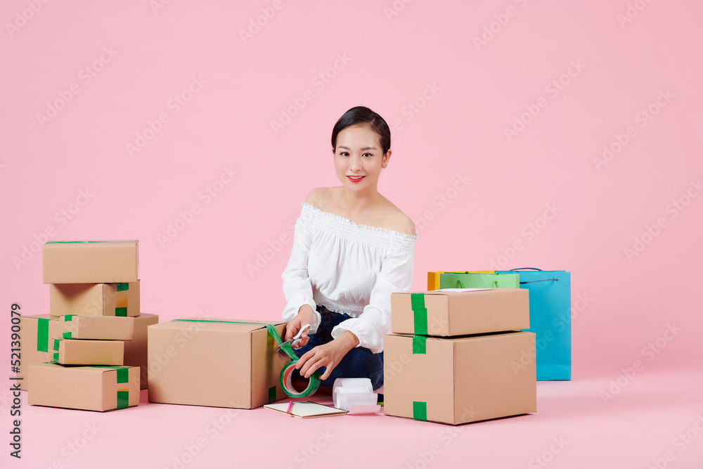 Asian woman packing goods with sticky tape for selling online, delivery concept. Asian woman packing goods with sticky tape for selling online, delivery concept.