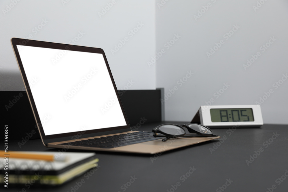 Modern laptop with blank screen on black table indoors, closeup. Mockup for design Modern laptop with blank screen on black table indoors, closeup. Mockup for design