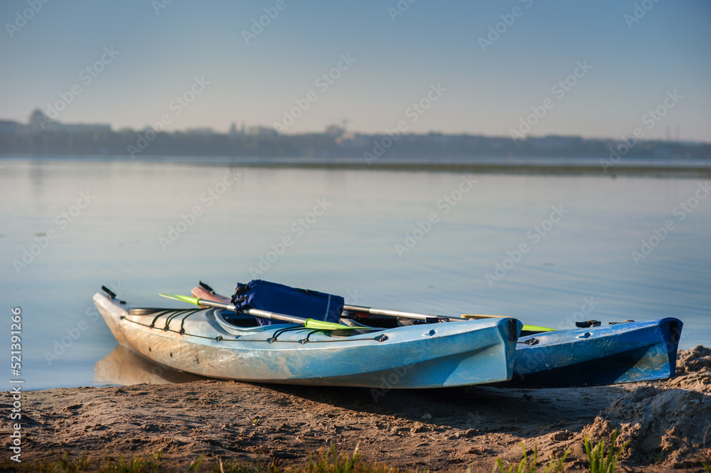 Naklejka premium two kayaks on the shore of the lake, active recreation at the weekend on the water
