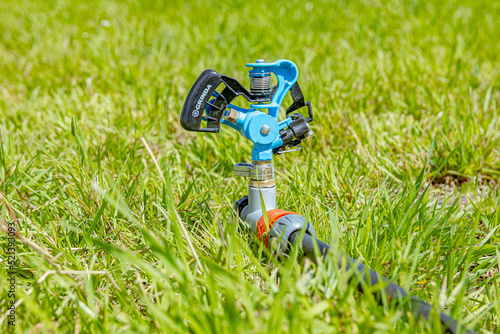 The lawn watering device is installed on the ground among the grass. Soft focus