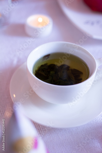Green tea in a cup and saucer, selective focus