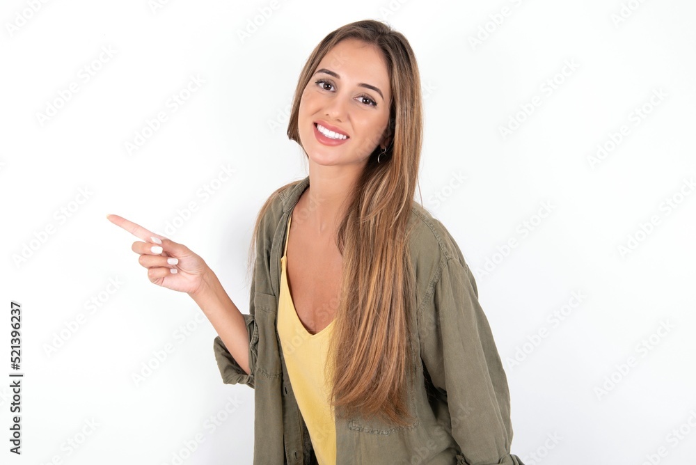 Profile photo of young beautiful woman wearing green overshirt over white background indicate finger empty space offer Profile photo of young beautiful woman wearing green overshirt over white background indicate finger empty space offer