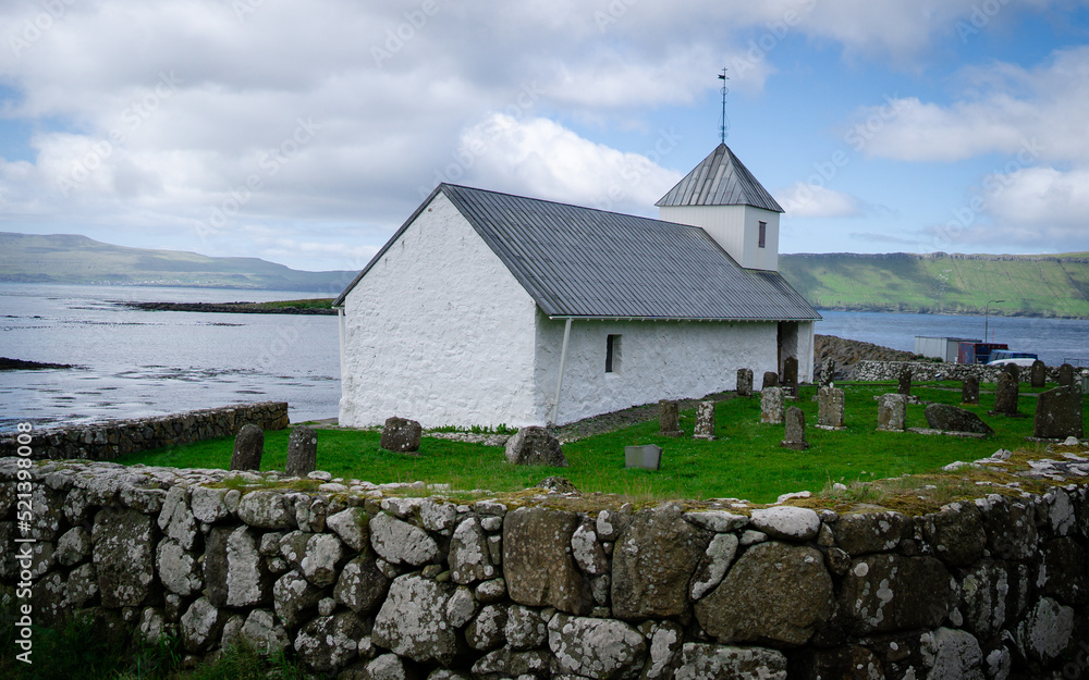 View of the village of Kirkjubour, famous for the ruins of an ancient cathedral, Kirkjubomururin, on the island of Streymoy. Old and beautiful architecture. Faroe Islands View of the village of Kirkjubour, famous for the ruins of an ancient cathedral, Kirkjubomururin, on the island of Streymoy. Old and beautiful architecture. Faroe Islands