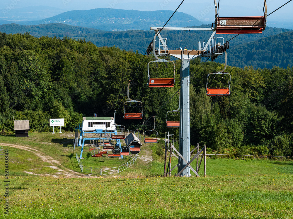 Ski resort of Gace, Slovenia with empty chair lifts and green background