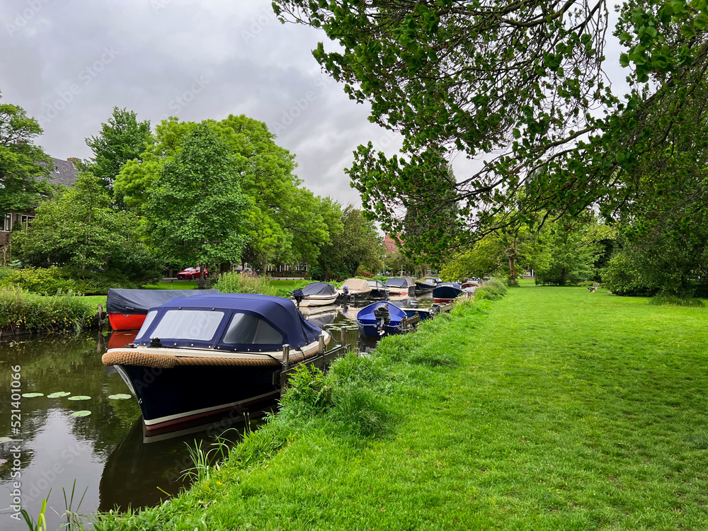 Beautiful view of green lawn near canal with different boats Beautiful view of green lawn near canal with different boats