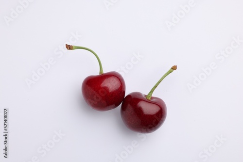 Two fresh sweet cherries on white background