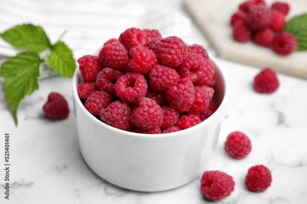 Bowl with fresh ripe raspberries on white marble table, closeup Bowl with fresh ripe raspberries on white marble table, closeup