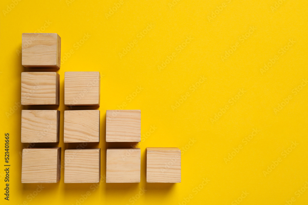Many wooden cubes and space for text on yellow background, flat lay. Management concept Many wooden cubes and space for text on yellow background, flat lay. Management concept