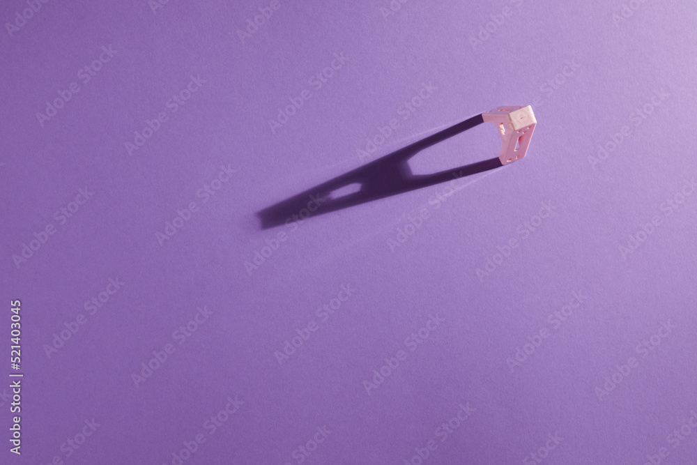 Top view of pink clothespin with sharp shadow on purple background. Top view of pink clothespin with sharp shadow on purple background.