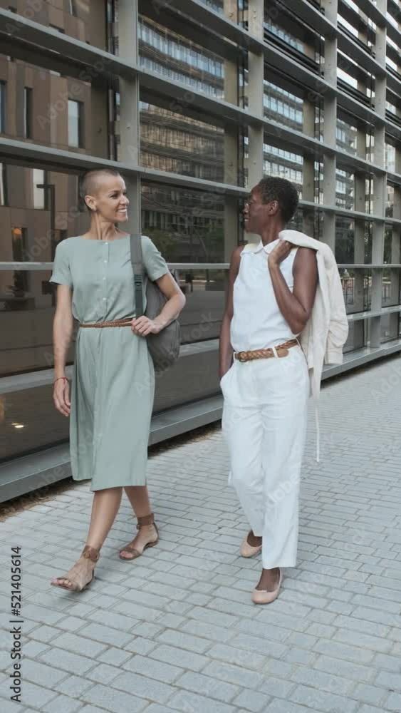Diverse colleagues walking on street and talking Diverse colleagues walking on street and talking