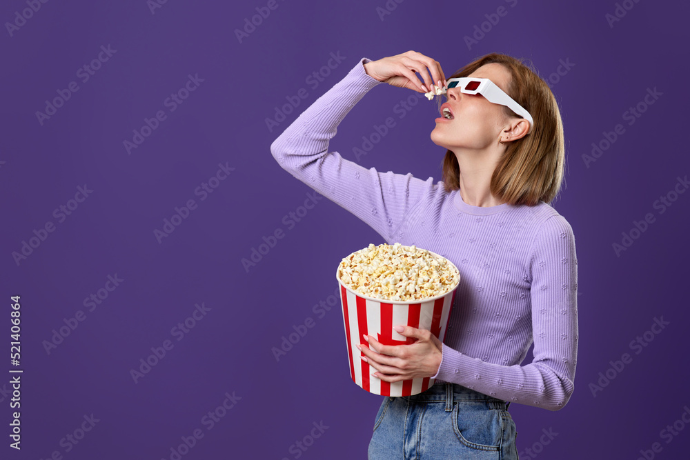 woman watching movie film, holding bucket of popcorn woman watching movie film, holding bucket of popcorn