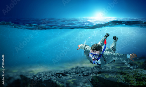 Young businessman in suit swimming