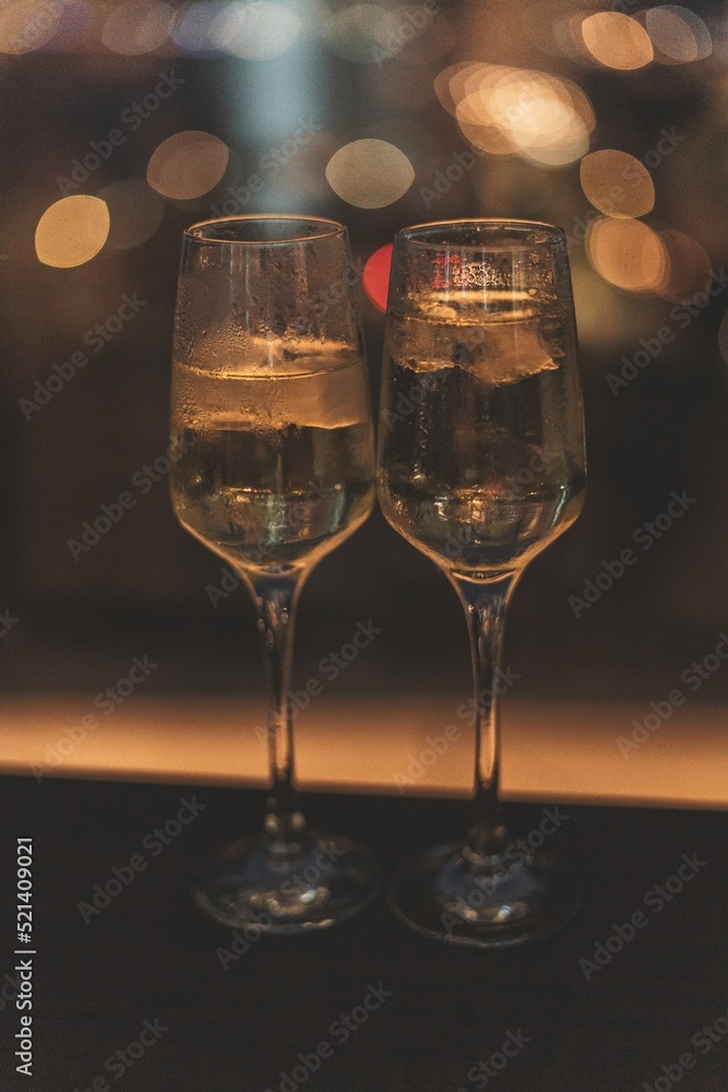 night shot of two glasses of prosecco with bokeh in the background night shot of two glasses of prosecco with bokeh in the background