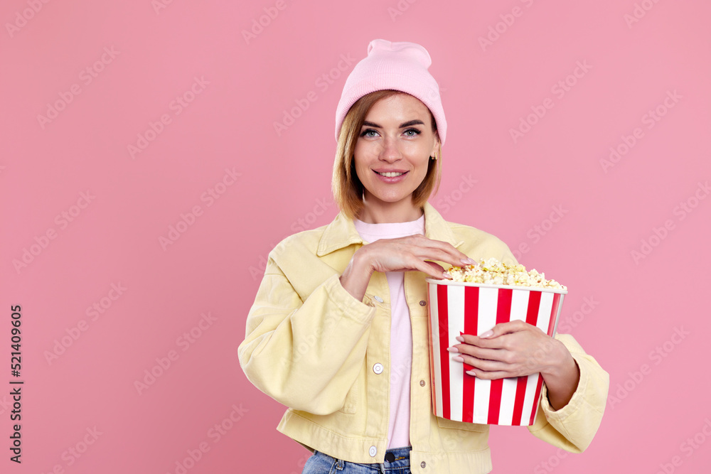 woman watching movie film, holding bucket of popcorn woman watching movie film, holding bucket of popcorn
