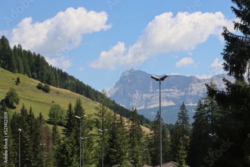 Coravara, Italy-July 16, 2022: The italian Dolomites behind the small village of Corvara in summer days with beaitiful blue sky in the background. Green nature in the middle of the rocks. 