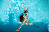Girl submerged under blue water
