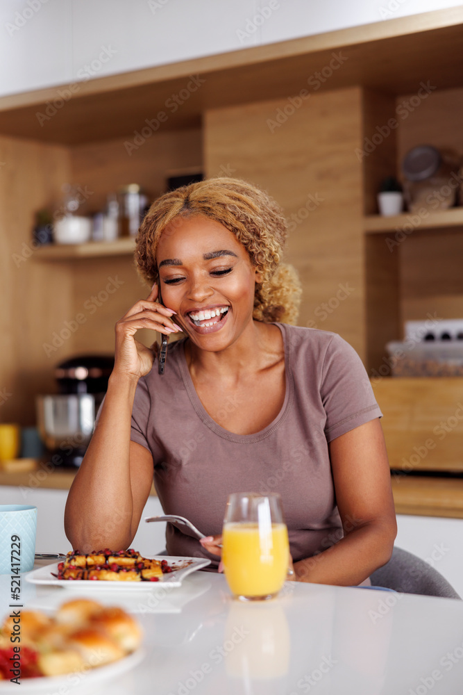 Woman speaking on the phone and having breakfast