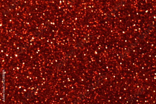 Red glitter texture background. Blurred photo of glowing red brown bokeh glitter background. Photo can be used for New Year, Christmas, Valentine and all celebration concept. 