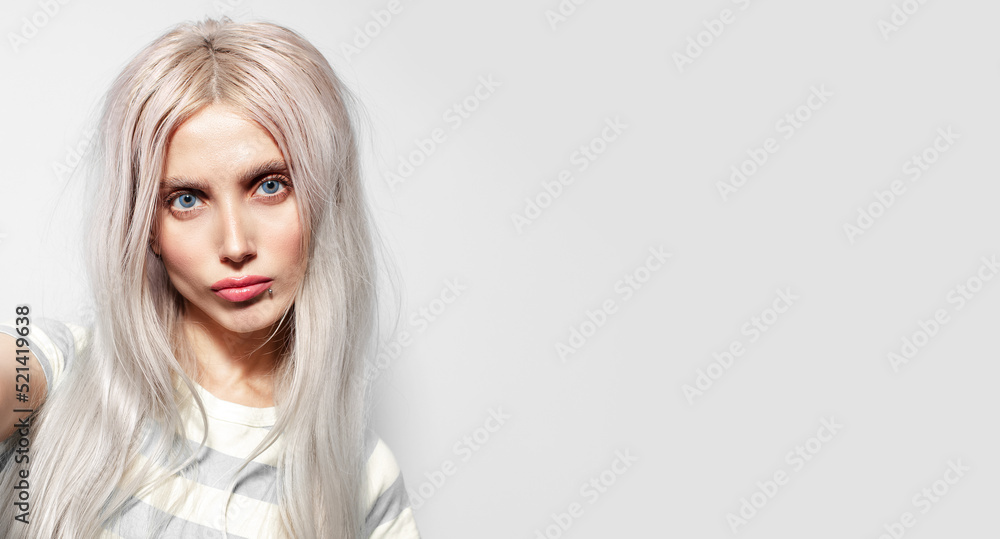 Studio close-up portrait of funny pretty girl with blonde hair on white background with copy space, panoramic banner. Studio close-up portrait of funny pretty girl with blonde hair on white background with copy space, panoramic banner.