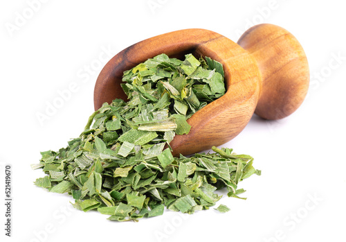 Dry chopped spring onion in wooden scoop, isolated on white background. Dried green onion or scallion. Spices and herbs.