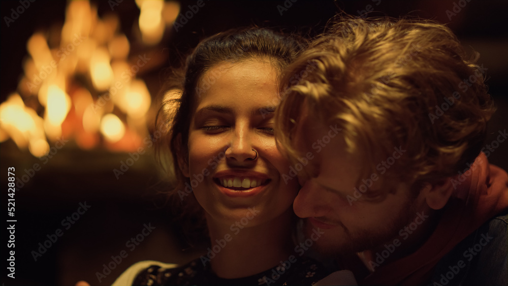 Cheerful couple enjoy cuddle fireplace closeup. Sensual lovers embrace on date.