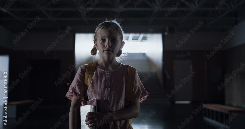 Worried schoolgirl walk down empty stairway alone. Girl enter dark corridor. Worried schoolgirl walk down empty stairway alone. Girl enter dark corridor.