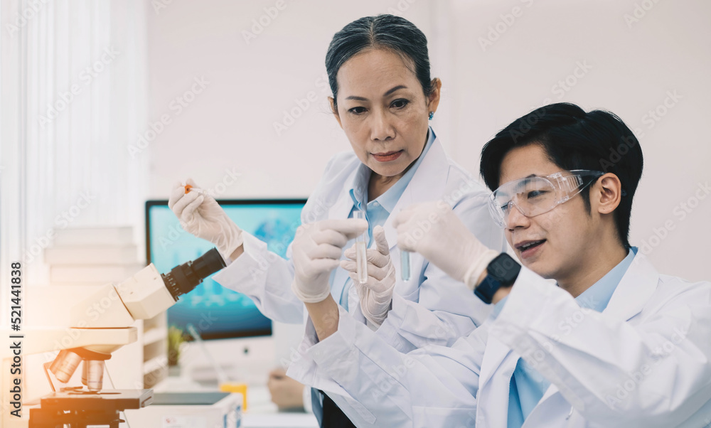 Asian scientists work in hospital pharmacology science research lab. Woman medical scientist and researchers teamwork analyzing innovative virus protective vaccines in health care biology laboratory Asian scientists work in hospital pharmacology science research lab. Woman medical scientist and researchers teamwork analyzing innovative virus protective vaccines in health care biology laboratory