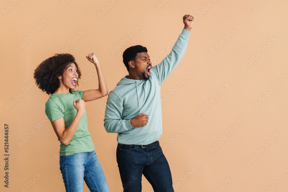 Black man and woman laughing and gesturing as winners Black man and woman laughing and gesturing as winners