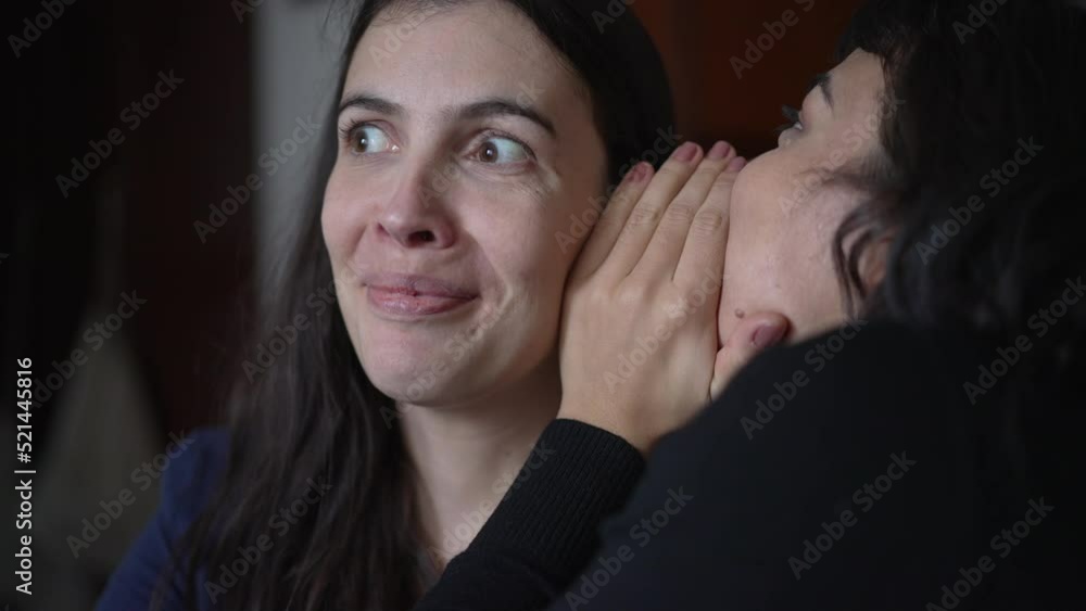 Friend telling secret to woman ear whispering. Young woman shock surprise reaction to gossip news. People sharing secrets Friend telling secret to woman ear whispering. Young woman shock surprise reaction to gossip news. People sharing secrets