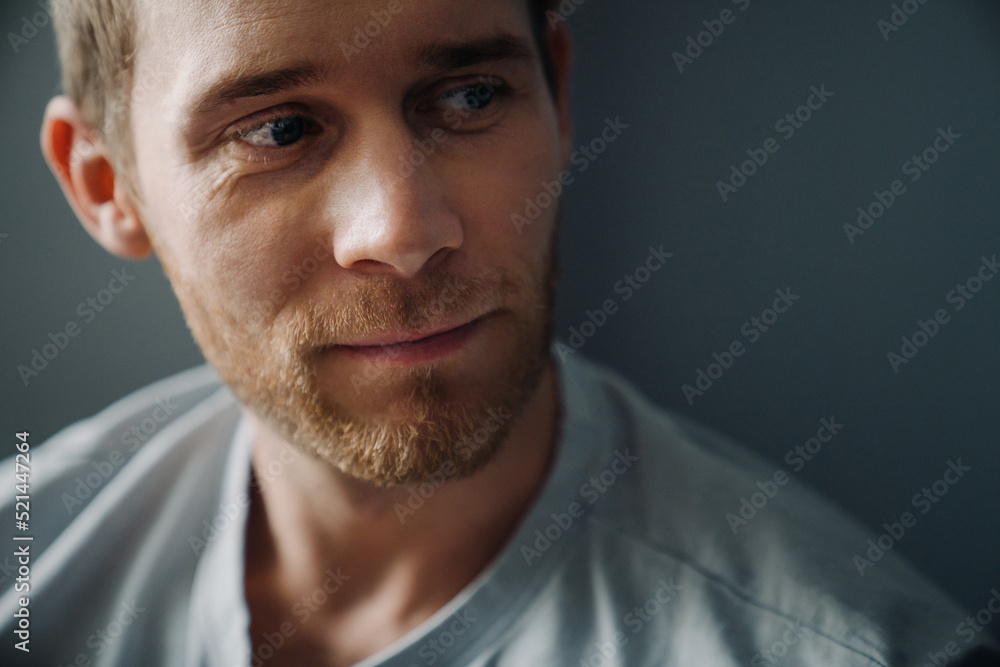 Obraz premium Young bearded man wearing t-shirt looking aside at copyspace at home