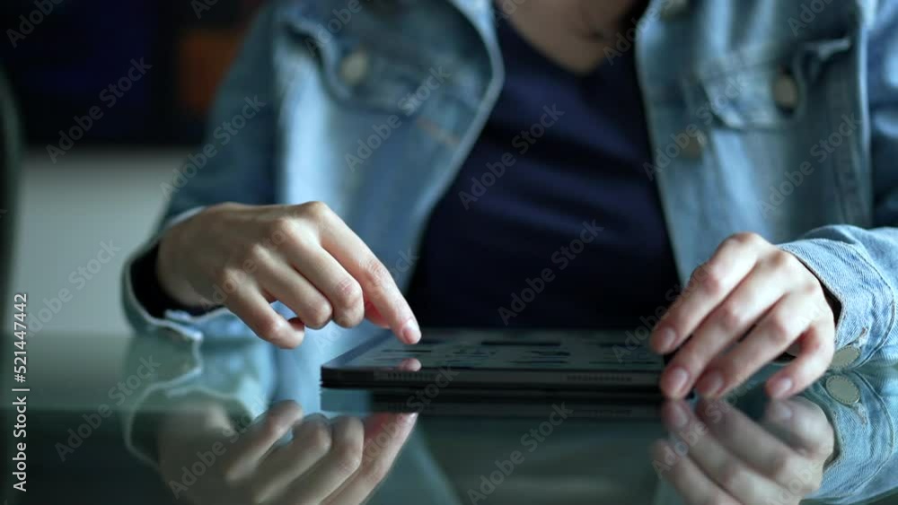 Hand scrolling online content on tablet screen. Closeup female hands touching modern digital device browsing internet online Hand scrolling online content on tablet screen. Closeup female hands touching modern digital device browsing internet online