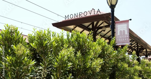 Low Angle Pan Of The Monrovia Metro Station Sign And Shelter With Bushes In The Foreground - Los Angeles, California photo