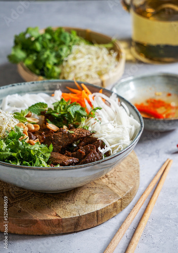 bowl of traditional Vietnamese salad - Bun Bo Nam Bo, with beef, rice noodles, fresh herbs, pickled vegetables and fish sauce