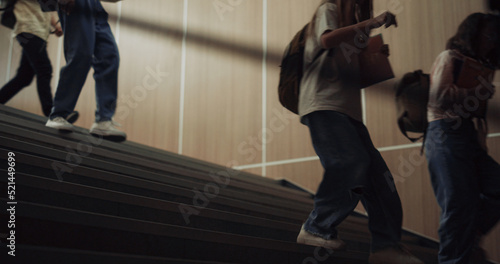 Group teenagers running downstairs school corridor. Children stepping stairway.