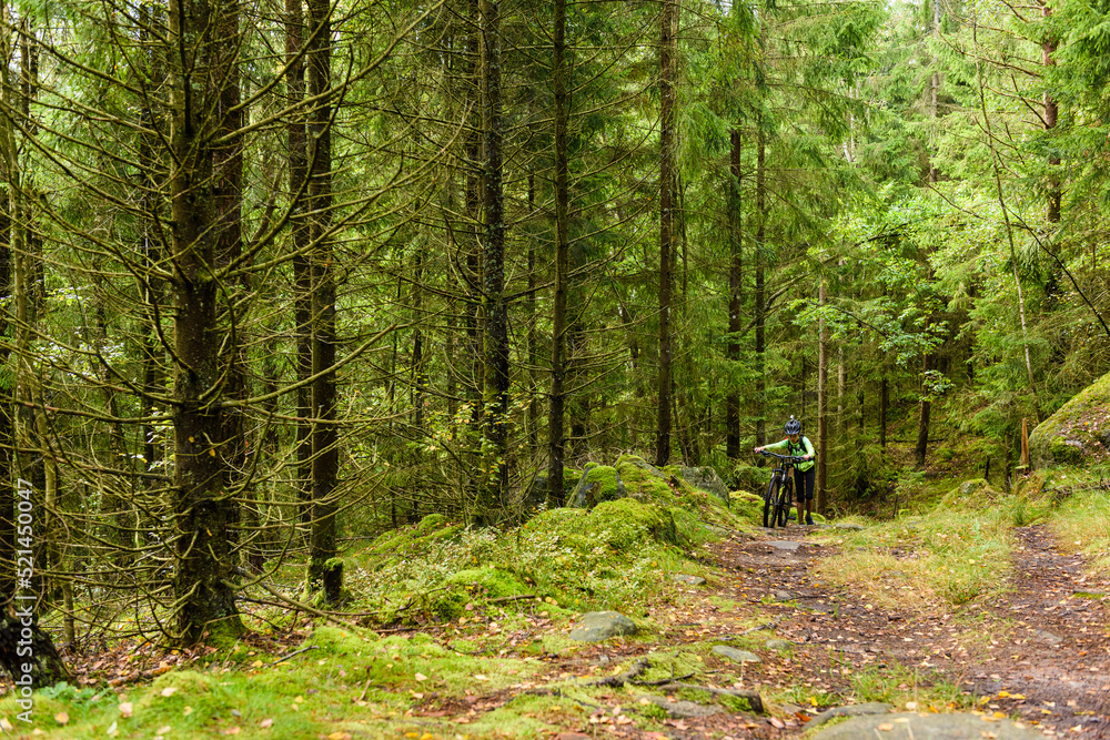 Boy walks with bike in forest