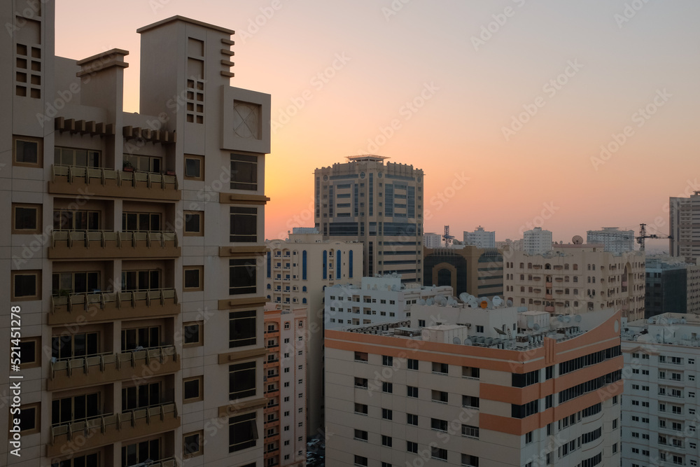 Balcony view of generic apartment buildings in the residential neighborhood of Al Qasimia in Sharjah, United Arab Emirates. Urban scene at sunset.