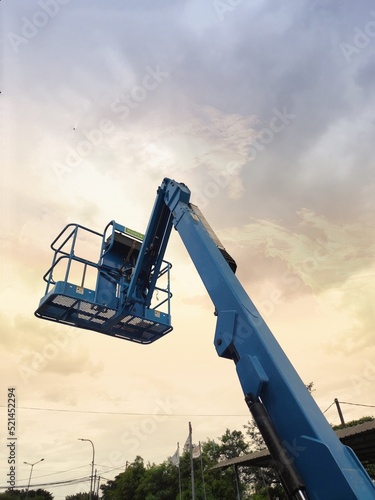 Manlift crane with platform lifting to the roof top of a building. Fire fighting equipment tool.