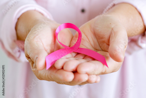 Woman hold pink ribbon as sign of October Breast Cancer Awareness month