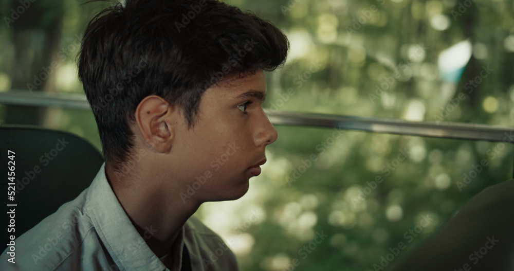 Indian boy sitting school bus alone close up. Teen schoolboy looking window. Indian boy sitting school bus alone close up. Teen schoolboy looking window.