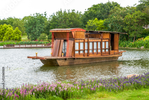 This traditional Chinese wooden boat is moored on the lake in the park photo