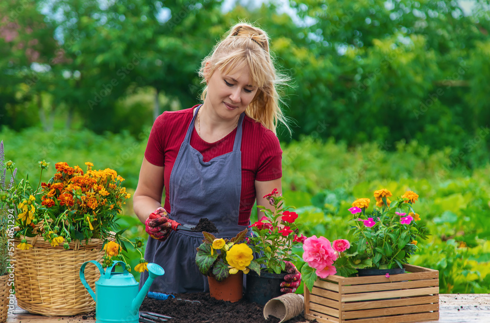 A woman is planting flowers in the garden. Selective focus.